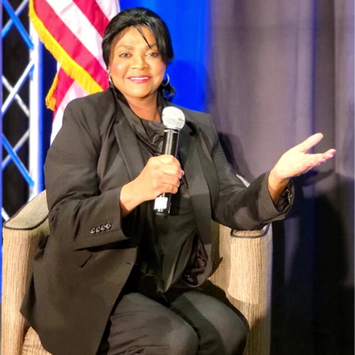 Dr. Cheryl Cooper on stage with a microphone